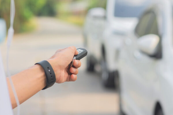 man using key fob to open his car's door from a distance